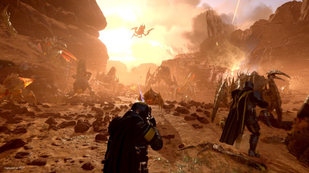 Helldivers 2: an orange-y haze as soldiers battle against large creatures.